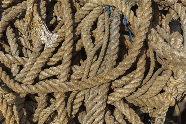 Close-up of old coiled mixed size ropes on the ground, Port of Gruz, Dubrovnik, Croatia, Europe