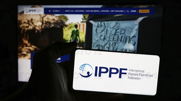 Stuttgart, Germany, 07-15-2024: Person holding smartphone with logo of International Planned Parenthood Federation (IPPF) in front of website. Focus on phone display, Europe