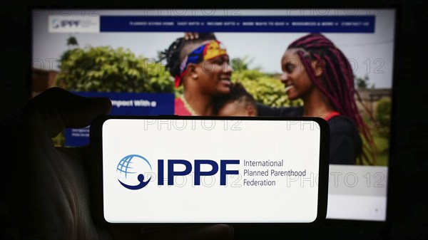 Stuttgart, Germany, 07-15-2024: Person holding cellphone with logo of International Planned Parenthood Federation (IPPF) in front of webpage. Focus on phone display, Europe