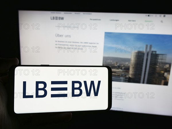 Stuttgart, Germany, 07-15-2024: Person holding smartphone with logo of German company Landesbank Baden-Wurttemberg (LBBW) in front of website. Focus on phone display, Europe