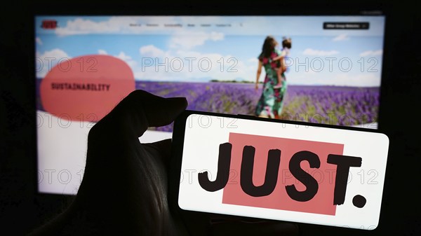 Stuttgart, Germany, 03-23-2024: Person holding smartphone with logo of British financial services company Just Group plc in front of website. Focus on phone display, Europe