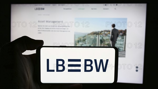 Stuttgart, Germany, 07-15-2024: Person holding cellphone with logo of German company Landesbank Baden-Württemberg (LBBW) in front of business webpage. Focus on phone display, Europe