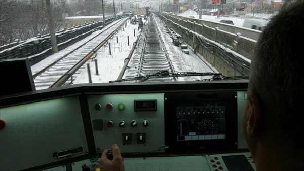 The driver controls the locomotive of the train. The city train goes to the station. A subway train runs through the snowy city