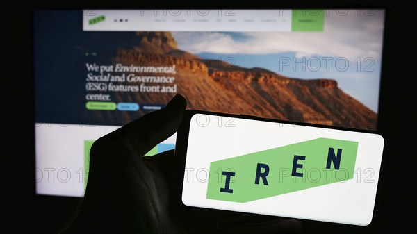 Stuttgart, Germany, 05-02-2024: Person holding smartphone with logo of Australian Bitcoin mining company Iris Energy Ltd. (IREN) in front of website. Focus on phone display, Europe