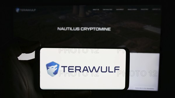 Stuttgart, Germany, 05-02-2024: Person holding cellphone with logo of US Bitcoin mining company TeraWulf Inc. in front of business webpage. Focus on phone display, Europe