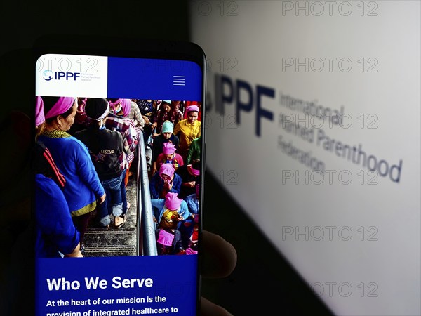 Stuttgart, Germany, 07-15-2024: Person holding cellphone with webpage of International Planned Parenthood Federation (IPPF) in front of logo. Focus on center of phone display, Europe