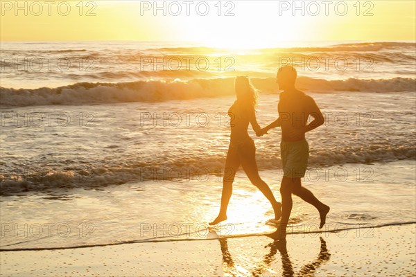 Couple at sunset at Playa Santa Teresa, Santa Teresa, Peninsula de Nicoya, Guanacaste, Costa Rica, Central America