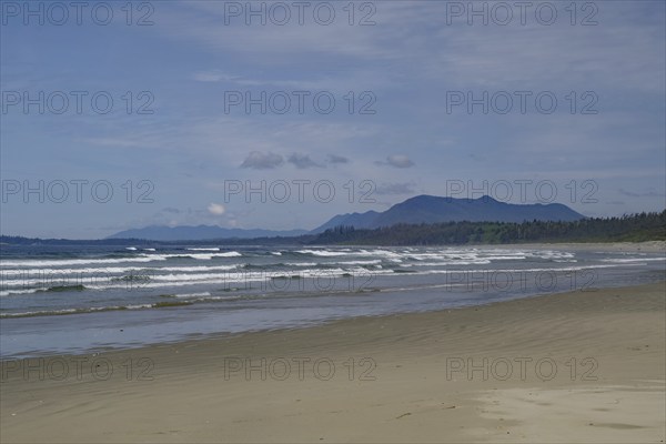 Endless empty sandy beach with swell and mountains in the background, Long Beach, Pacific Rim National Park, Vancouver Island, British Columbia