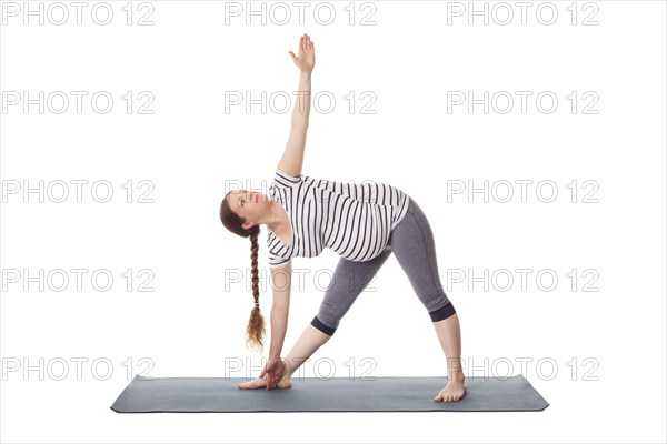 Pregnancy yoga exercise, pregnant woman doing asana Utthita trikonasana, extended triangle pose isolated on white background