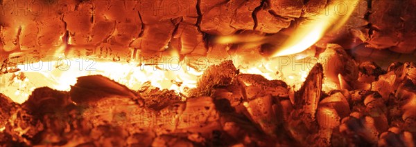 Glowing flames in the tiled stove, open fire