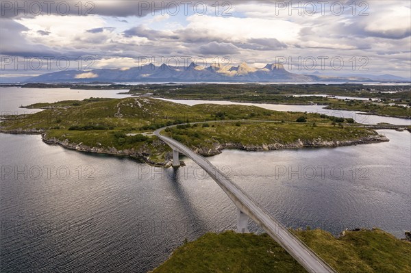 Road with bridge over Inse, behind the mountain range Seven Sisters, Herøy island, Helgeland coast, Nordland, Norway, Europe