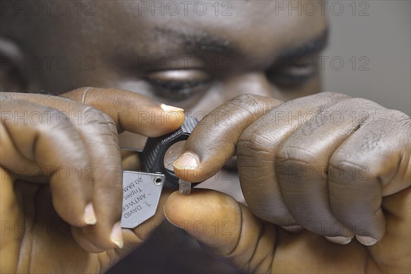 Diamond dealer looking at a diamond through a magnifying glass, Koidu, Koidu-Sefadu, Kono District, Eastern Province, Sierra Leone, Africa