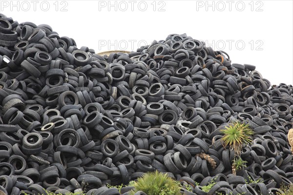 Old car tyres lie on stockpiles for recycling