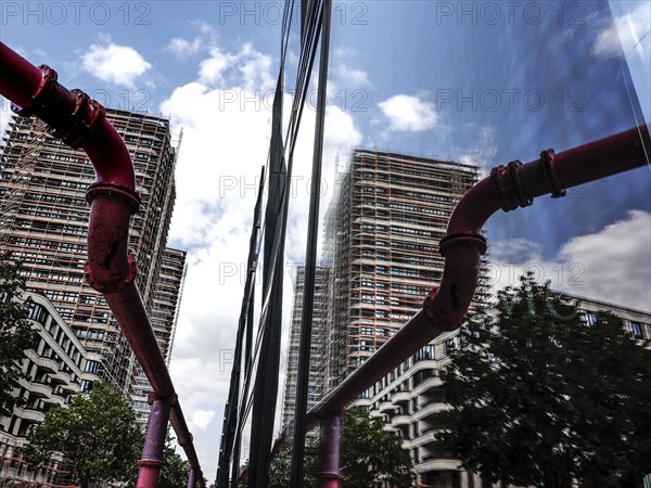 A new high-rise building is reflected in a glass façade, groundwater is pumped through pipes, new buildings at the East Side Gallery, Berlin, 02.07.2023