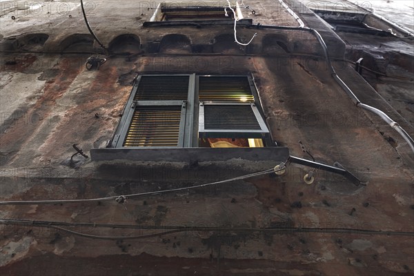 Light shines through a shutter of a residential building in the historic centre, Genoa, Italy, Europe