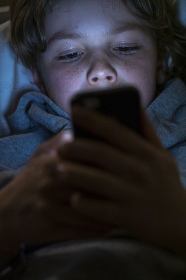 A boy plays computer games on a mobile phone, smartphone