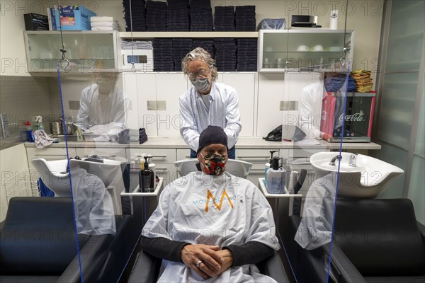 Hairdressing salon in Essen-Rüttenscheid, first customer after 6 weeks, shop closed due to Corona, hairdresser and customer with mouth-nose protection, breathing mask, Plexiglas protective walls, spit protection, when washing hair, distance regulation, Essen, North Rhine-Westphalia, Germany, Europe