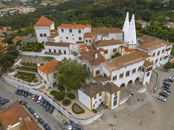 Overview of a historic castle with white towers and orange-red roofs, surrounded by a city, aerial view, Royal Palace, Palácio Nacional de Sintra, National Palace, Sintra, Lisbon, Portugal, Europe