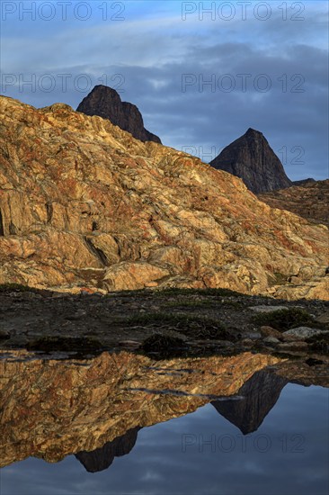 Mountains and rocks reflected in fjord, midnight sun, mood, Scoresby Sound, East Greenland, Greenland, North America