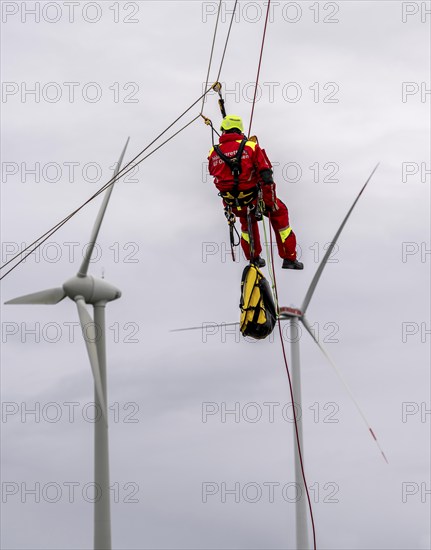 Height rescuers from the Oberhausen fire brigade practise abseiling from a wind turbine from a height of 150 metres after rescuing an accident victim from the nacelle, Issum, North Rhine-Westphalia, Germany, Europe