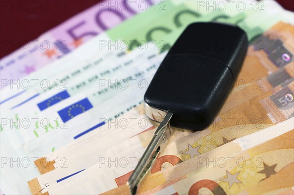 Euro banknotes and car keys as a symbol for car costs