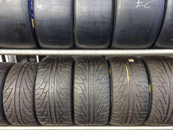 Shelf with racing tyres Car tyres Tyres for car racing top Slicks without tread Tyre tread for dry race track Dry track bottom Rain tyres with deep tread for wet track Race track, international