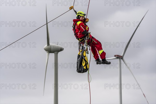 Height rescuers from the Oberhausen fire brigade practise abseiling from a wind turbine from a height of 150 metres after rescuing an accident victim from the nacelle, Issum, North Rhine-Westphalia, Germany, Europe