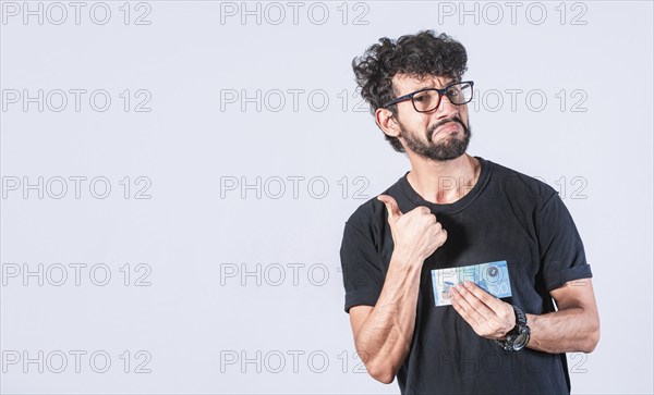 Man holding a banknote with thumb up isolated. Person holding bill with gesture aproved isolated