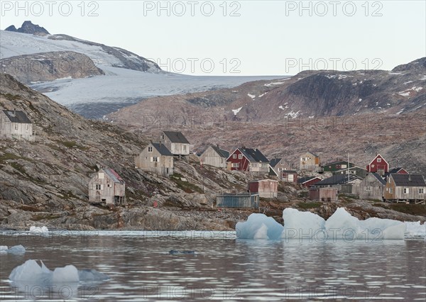 Icebergs in front of wooden houses in the Inuit settlement of Tiniteqilaaq, Sermilik Fjord, East Greenland, Greenland, North America