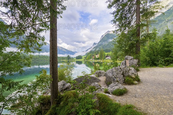 Hintersee with rocks and trees in the foreground, cloudy sky, Ramsau, Berchtesgaden National Park, Berchtesgadener Land, Upper Bavaria, Bavaria, Germany, Europe