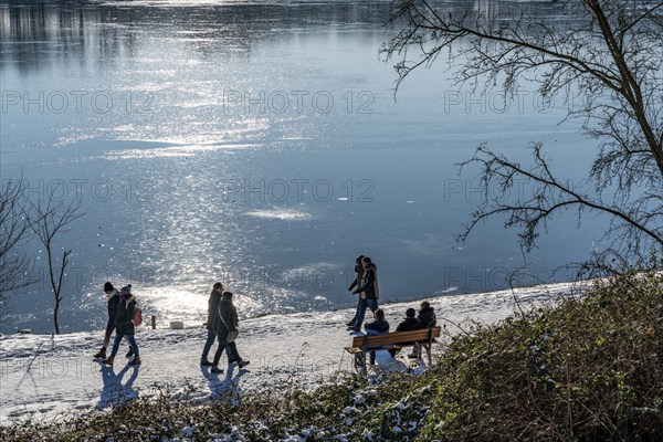 Winter in the Ruhr area, Lake Baldeney, snow-covered, partly frozen lake, walkers on the lakeside path, west bank, Essen, North Rhine-Westphalia, Germany, Europe