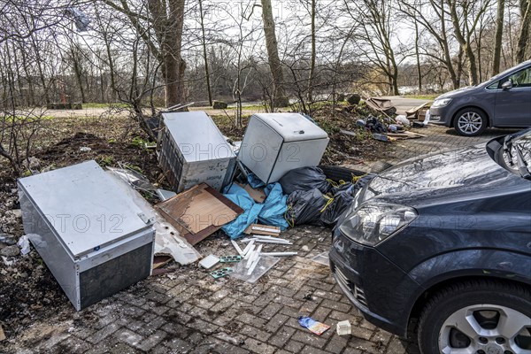 Illegal waste disposal in a car park, in a wooded area, tyres, furniture, refrigerators, household waste, oil cans, Oberhausen North Rhine-Westphalia, Germany, Europe