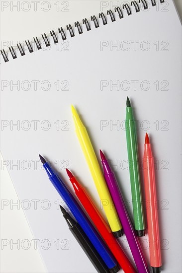 Watercolor pens brush, assortment, on a drawing album, artist's desk, top view, close-up, selective focus