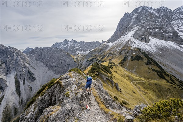 Mountaineers on a hiking trail on the ridge of Hahnkampl, mountain panorama with rocky steep peaks, view of summit Lamsenspitze, in autumn, Karwendel Mountains, Alpenpark Karwendel, Tyrol, Austria, Europe