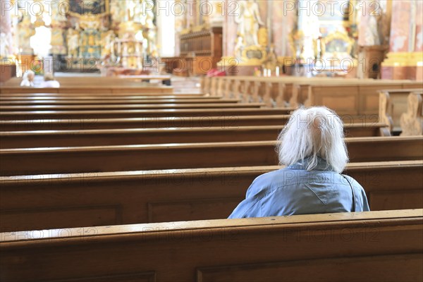 Old grey-haired woman as the only churchgoer, interior of the Cistercian Abbey Church Fürstenfeld in Fürstenfeldbruck, Upper Bavaria, Bavaria, Germany, Europe