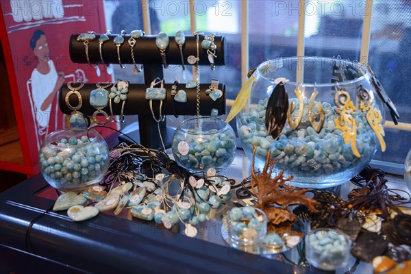 Various pieces of jewellery in aqua tones presented in glass jars on a sales table, sale of Larimar, Bayahibe, Dominican Republic, Hispaniola, Caribbean, America, Central America