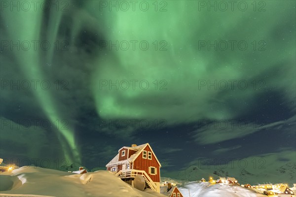 Northern Lights, Aurora borealis over red house, Inuit settlement, Winter, Tasiilaq, East Greenland, Greenland, North America