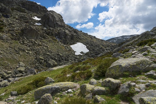 Mountainous landscape with rocky terrain and scattered patches of snow under a blue sky with clouds, hiking area, Reserva national de Gredos, Garganta de Prado Puerte, Prado Puerte Gorge, Sierra de Gredos, Ávila, Avila, Madrid, Spain, Europe