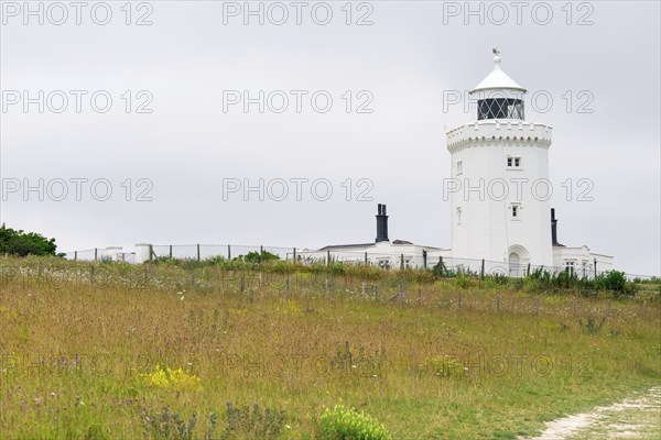 A lighthouse overlooks a natural landscape under a cloudy sky, South Foreland Lighthouse, White cliffs of Dover, Kent, England, Great Britain