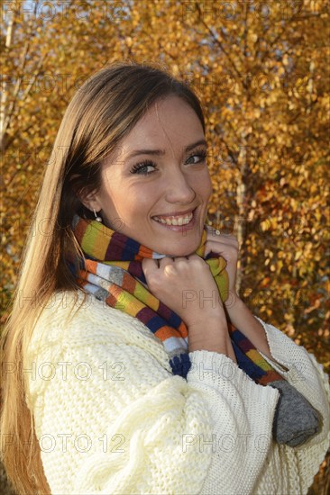 Portrait of young beautiful smiling woman, 30 years old, outdoors in forest with autumn colors in Ystad, Skåne County, Sweden, Scandinavia, Europe