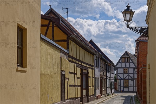 The market street with half-timbered houses and other old buildings, covered with cobblestones, in the old town of Tangermünde, Hanseatic town in the Altmark. Saxony-Anhalt, Germany, Europe