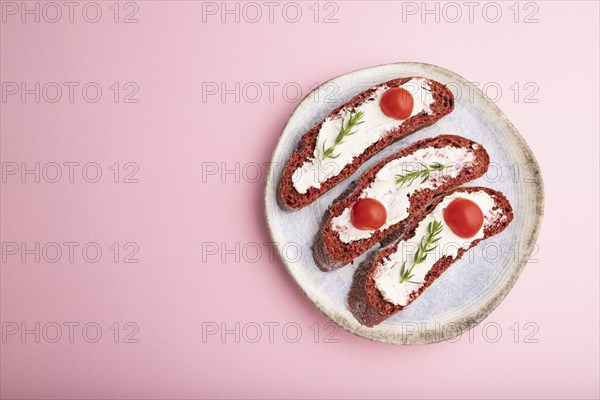 Red beet bread sandwiches with cream cheese and tomatoes on pastel pink background. top view, flat lay, copy space