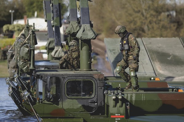 An engineer soldier stands on an amphibious vehicle of the type Amphibie M3 of the Bundeswehr, taken during the military exercise 'Wettiner Schwert' near Tangermünde, 26.03.2024. 'Wettiner Schwert' is part of the Quadriga exercise of the Bundeswehr and the NATO large-scale manoeuvre Steadtfast Defender 2024