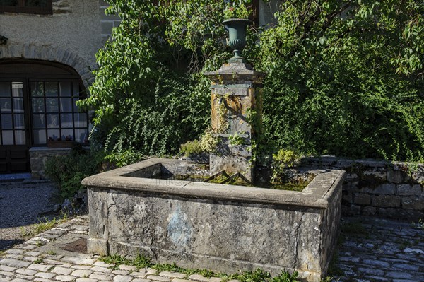 Old historic fountain with curved tap Water spout for permanent drinking water supply Clean drinkable water for human consumption Food with sign Eau potable, above goblet Cup vase for without flowers, Les Planches-prés-Arbois, Bourgogne-Franche-Comté, Département Jura, France, Europe