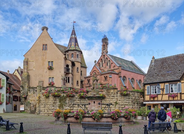 The St. Leon fountain on Saint-Leon Square in the centre of Eguisheim in Alsace. Well-kept half-timbered houses and floral decorations characterise the town centre. The town is classified as one of the Plus beaux villages de France. Eguisheim, Haut-Rhin, France, Europe