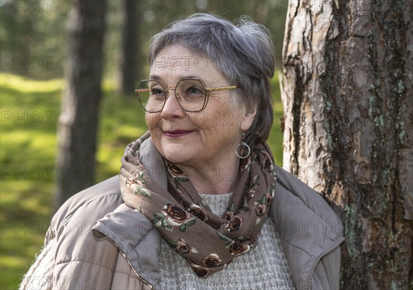 Portrait of elderly woman, 65 years old, enjoying nature in the forest in Ystad, Skåne, Sweden, Scandinavia, Europe