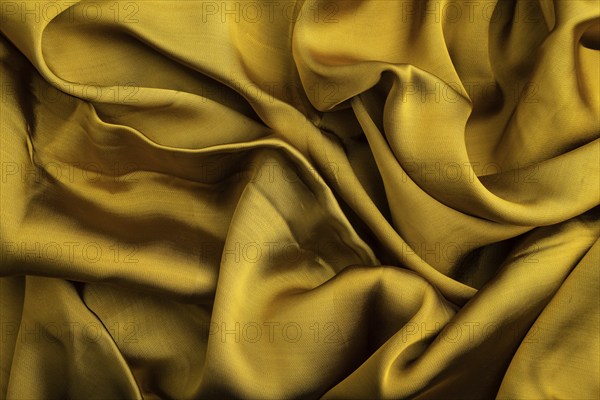 Fragment of yellow and green tissue. Side view, synthetic textile background and texture. wave concept, abstract