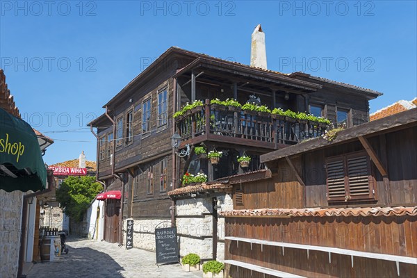 Wooden house with flower-planted balconies and various signs, in a cobblestone alley, Black Sea, Nesebar, Nessebar, Burgas, Bulgaria, Europe