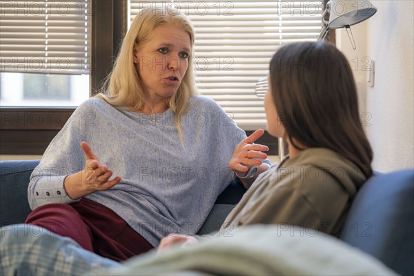 Mother and daughter, teenage, 13 years old, in a confidential conversation, at home