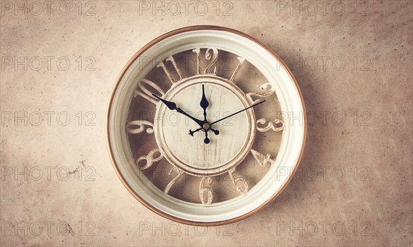 Mechanical wall clock, transparent, beige color, on a light painted wall, rustic style, vintage, no people